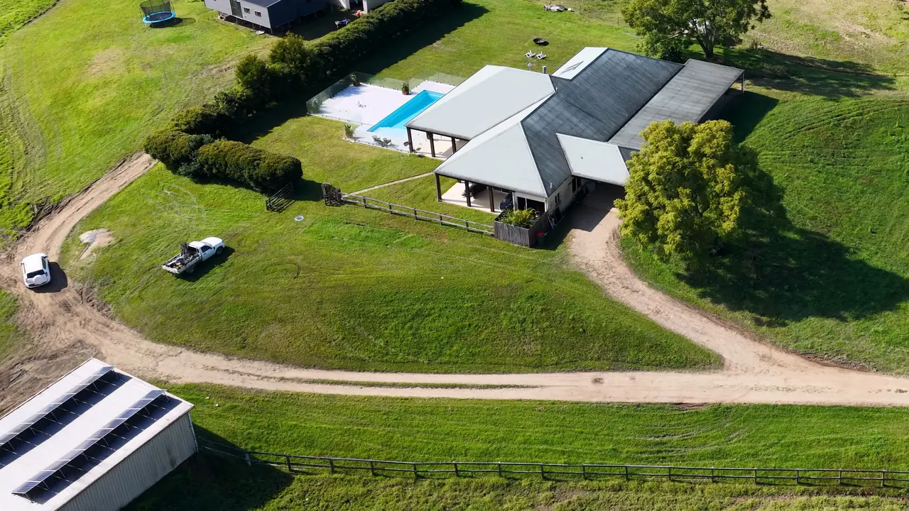 Aerial view of a rural house with a pool and paddocks