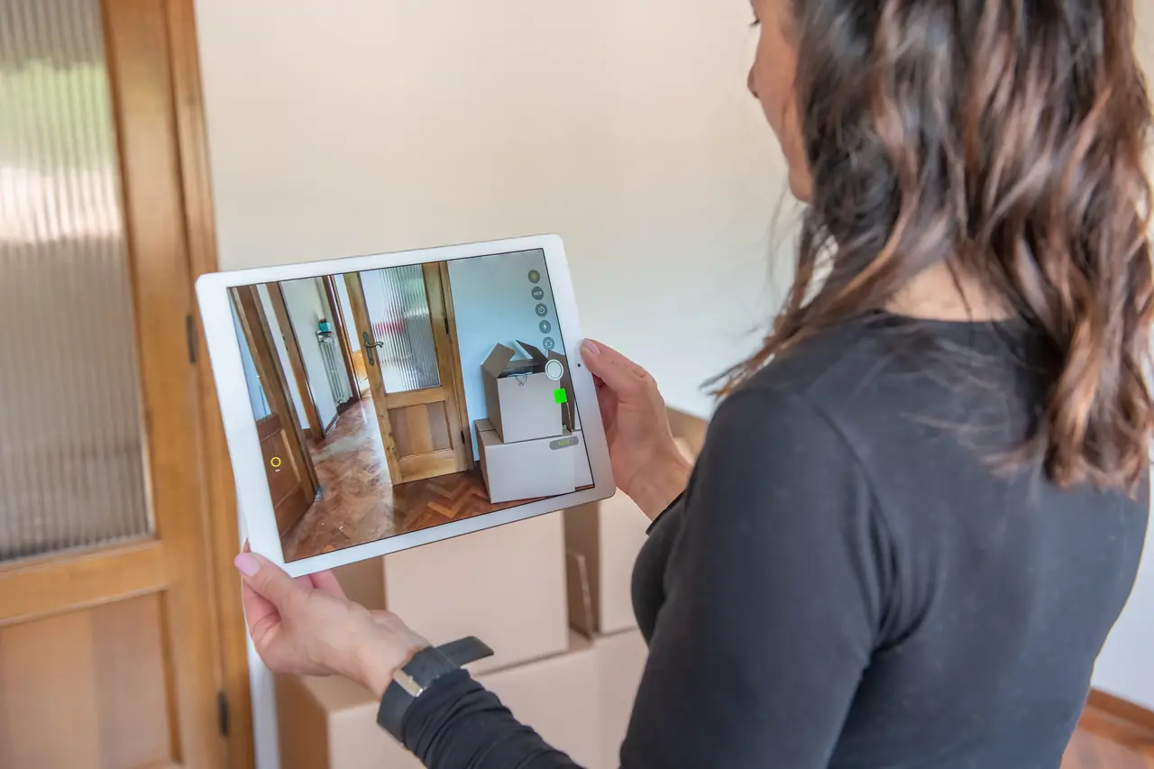 Hand holding a tablet showing a virtual tour